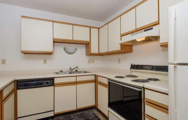 a kitchen with black and white appliances. Fargo, ND Twin Parks Apartments.