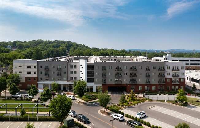 an aerial view of a large building with cars parked in a parking lot