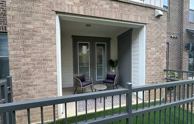 a patio with two chairs and a table on a balcony