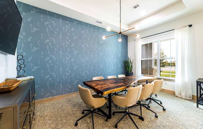 a conference room with a large table and chairs and a blue wall at The Parker Austin, Pflugerville, Texas