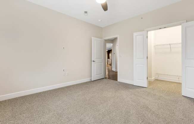 an empty living room with white doors and carpet