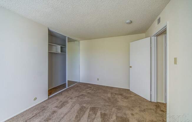 a bedroom with a closet and an open door at Terrace View Apartments, Daly City, CA 94015