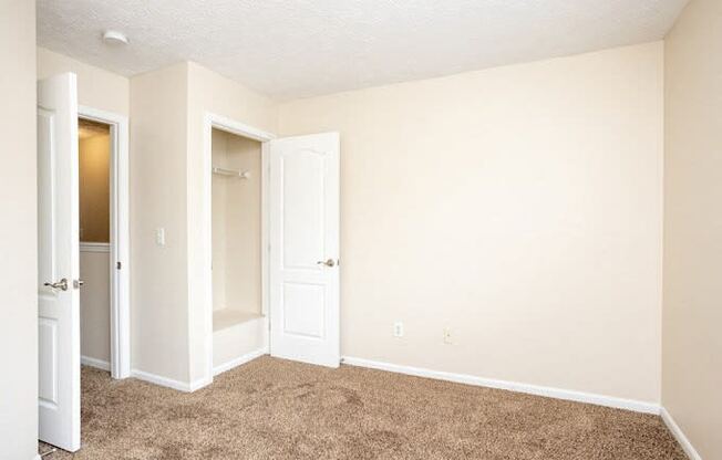 an empty room with an open door and a closet