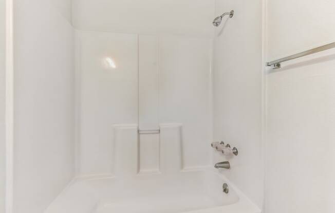 a white bathroom with a shower and a tub