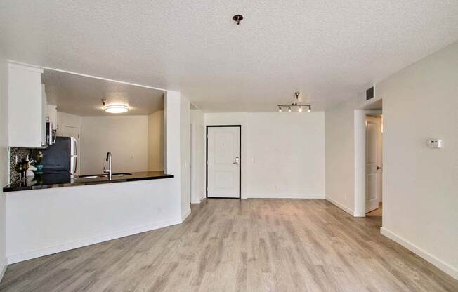 an empty living room with a kitchen in the background  at Masselin Park West, California