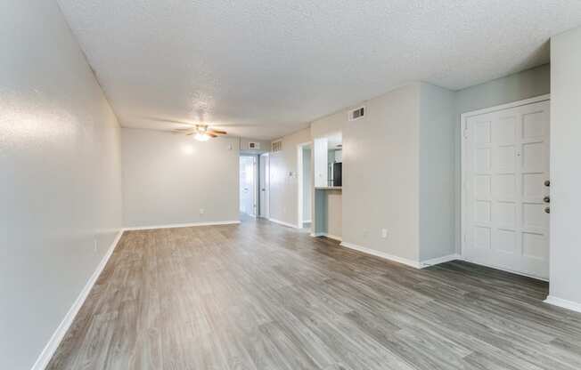 the spacious living room and dining room of an apartment