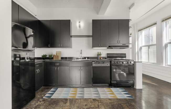 a kitchen with stainless steel appliances and black cabinets