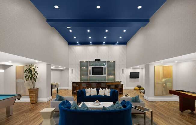 a living room with a blue ceiling and a pool table