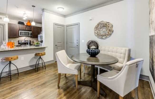 A kitchen with a white table and chairs.