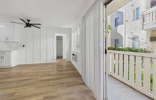 A long hallway with a fan and white walls.