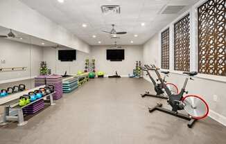 a gym with exercise equipment and a tv on the wall