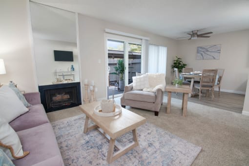 model apartment living room with a couch and a chair and a fireplace and dining room
