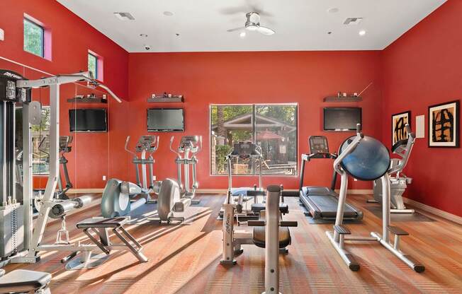 A gym with a variety of equipment including treadmills, weights, and exercise machines.