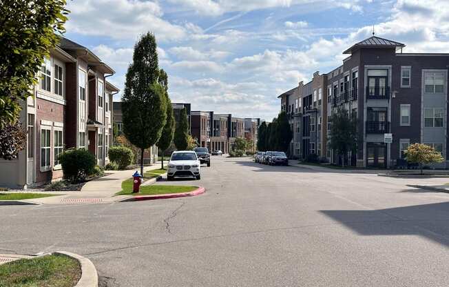 A street view of a residential area with cars parked on the side of the road.