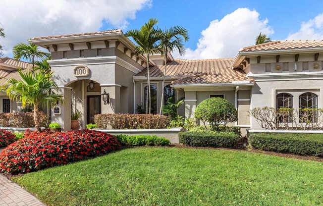 A house with a well-manicured lawn and a clear blue sky above.