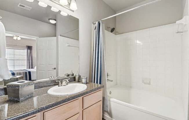 a bathroom with a sink and a tub and a mirror