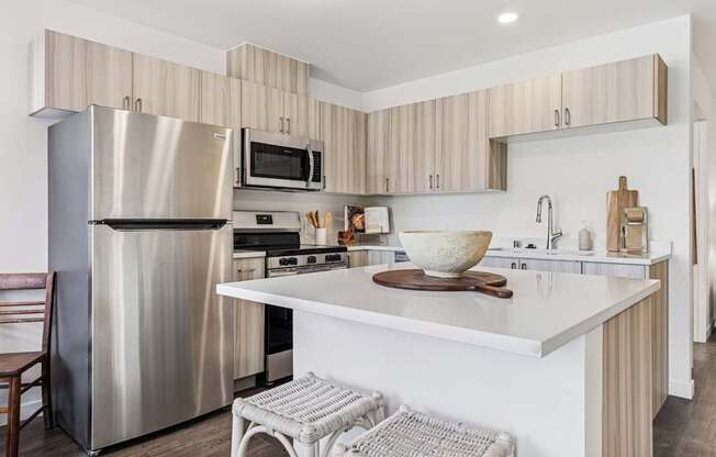 A modern kitchen with a stainless steel refrigerator and a white countertop.