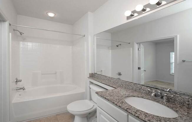A white bathroom with a toilet, sink, and bathtub.