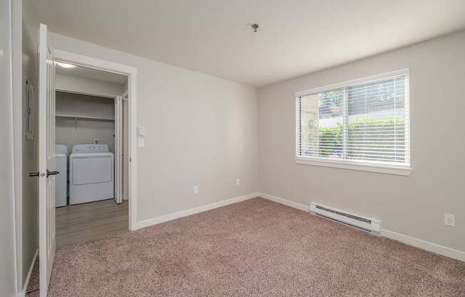 A room with a window and a door leading to another room.