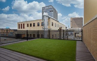 a yard on a balcony with a city in the background