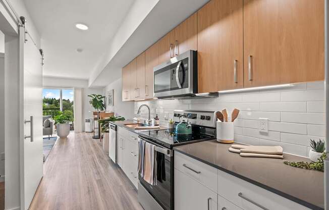 A modern kitchen with white cabinets and a black countertop.
