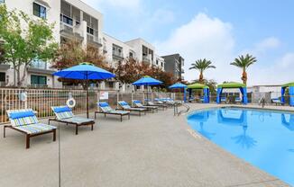 a group of lawn chairs sitting on top of a blue pool of water