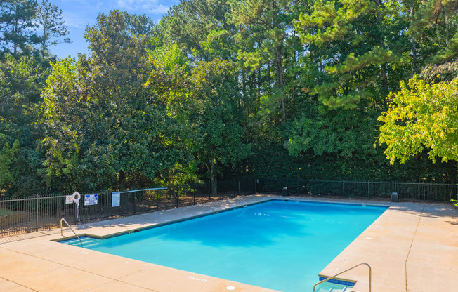 a swimming pool with trees in the background