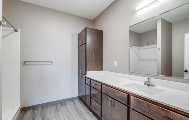 an empty bathroom with a large mirror and a sink