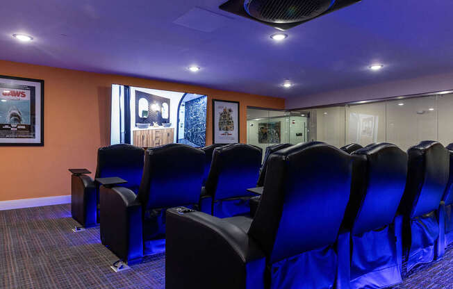 a conference room with blue chairs and a projector screen