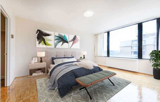 A bedroom with a bed, a bench, and a potted plant.