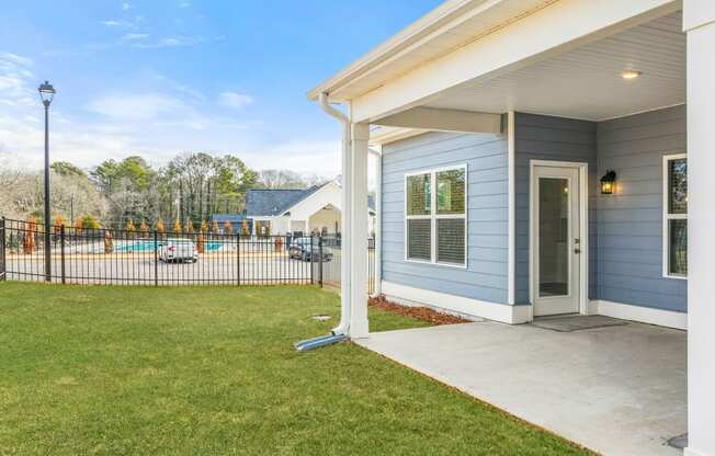 the entrance to a house with a yard and a fence