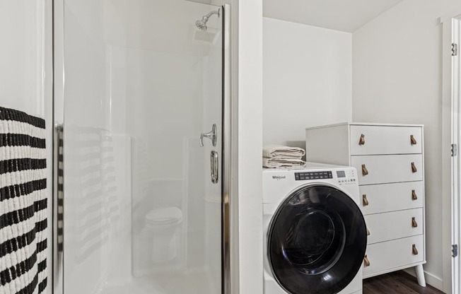 A black and white striped towel hangs on a glass door.