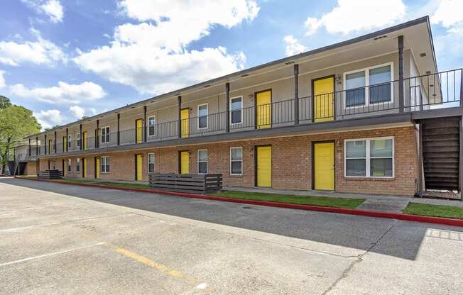 an exterior view of a brick apartment building with yellow doors at The Hub at Baton Rouge, Louisiana, 70808