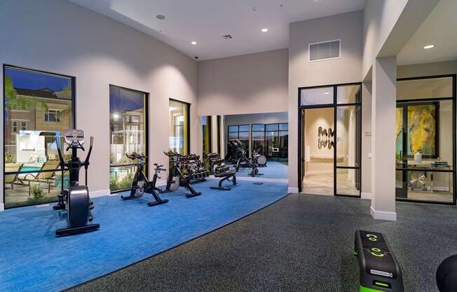 A gym with a row of exercise bikes and a row of exercise machines.