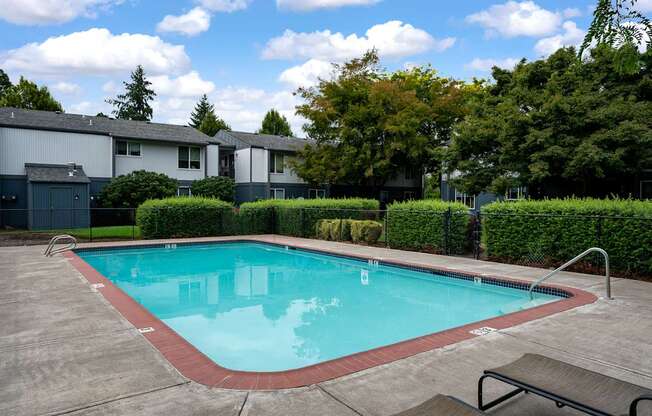 A small pool with a bench and a fence around it.