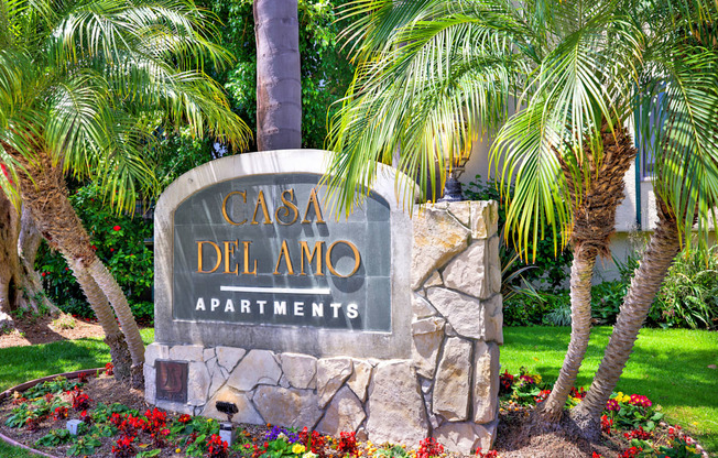 a sign for the casa del amo apartments in front of palm trees at Casa Del Amo Apartments, Torrance, 90505