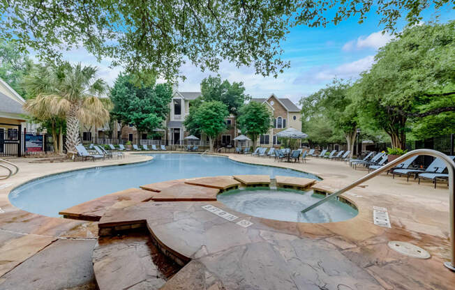 a swimming pool with chairs and trees and a resort style pool