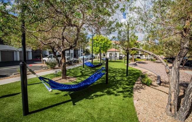 Colton Apartments A blue hammock is suspended between two poles in a grassy area.