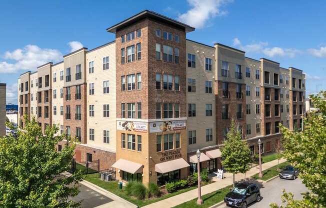 A large apartment complex with a parking lot in front.