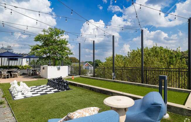 a backyard with a chess board and a lawn