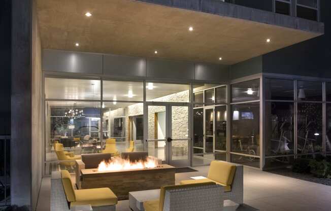 a fire pit in the middle of a patio with chairs and tables