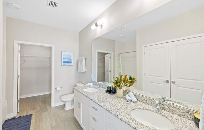 a bathroom with two sinks and a shower and a toilet