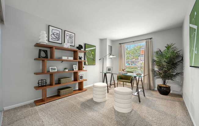 A room with a carpeted floor, a wooden shelf, a green chair, a white ottoman, and a potted plant.
