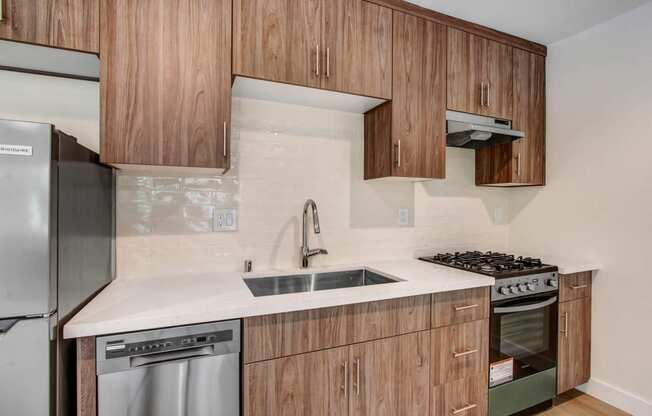 a kitchen with wooden cabinets and a sink and a refrigerator