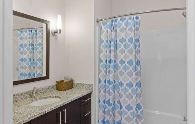 a bathroom with a shower sink and mirror