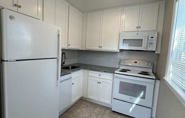 a kitchen with white appliances and white cabinets