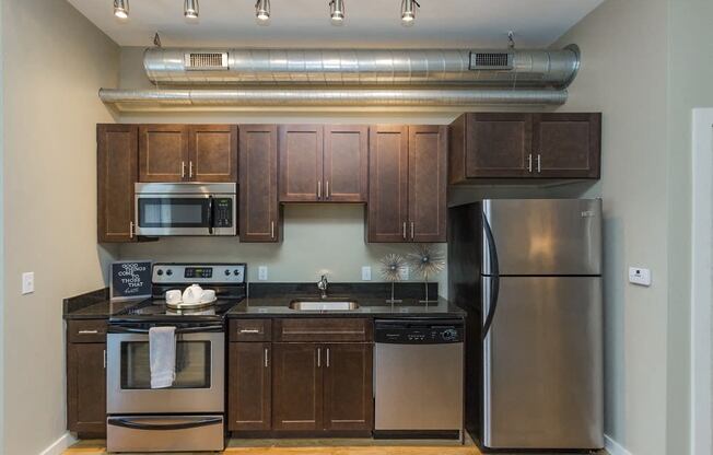 Gale Lofts - Spacious Kitchen with Wood-Style Cabinets and Stainless Steel Appliances