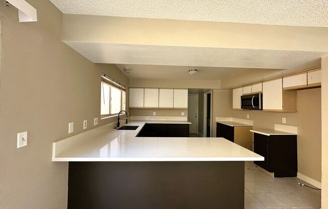 Newly renovated home with brand new kitchen and flooring downstairs! Home features a large living room with a fireplace and a separate family room! Brand new large kitchen cabinets and countertops! A large backyard! And is nearby the Summerlin Parkway hig