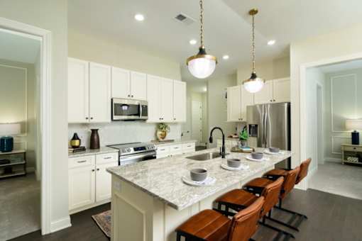 a kitchen with white cabinets and a large island with a marble countertop at Fairfax, Grandview, OH