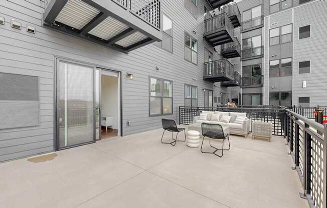 A patio area with a table and chairs is surrounded by a metal fence.